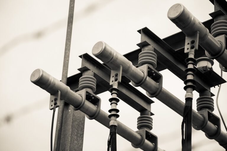 Selective Focus Greyscale Shot of Powerlines, Connections, and Transformer
